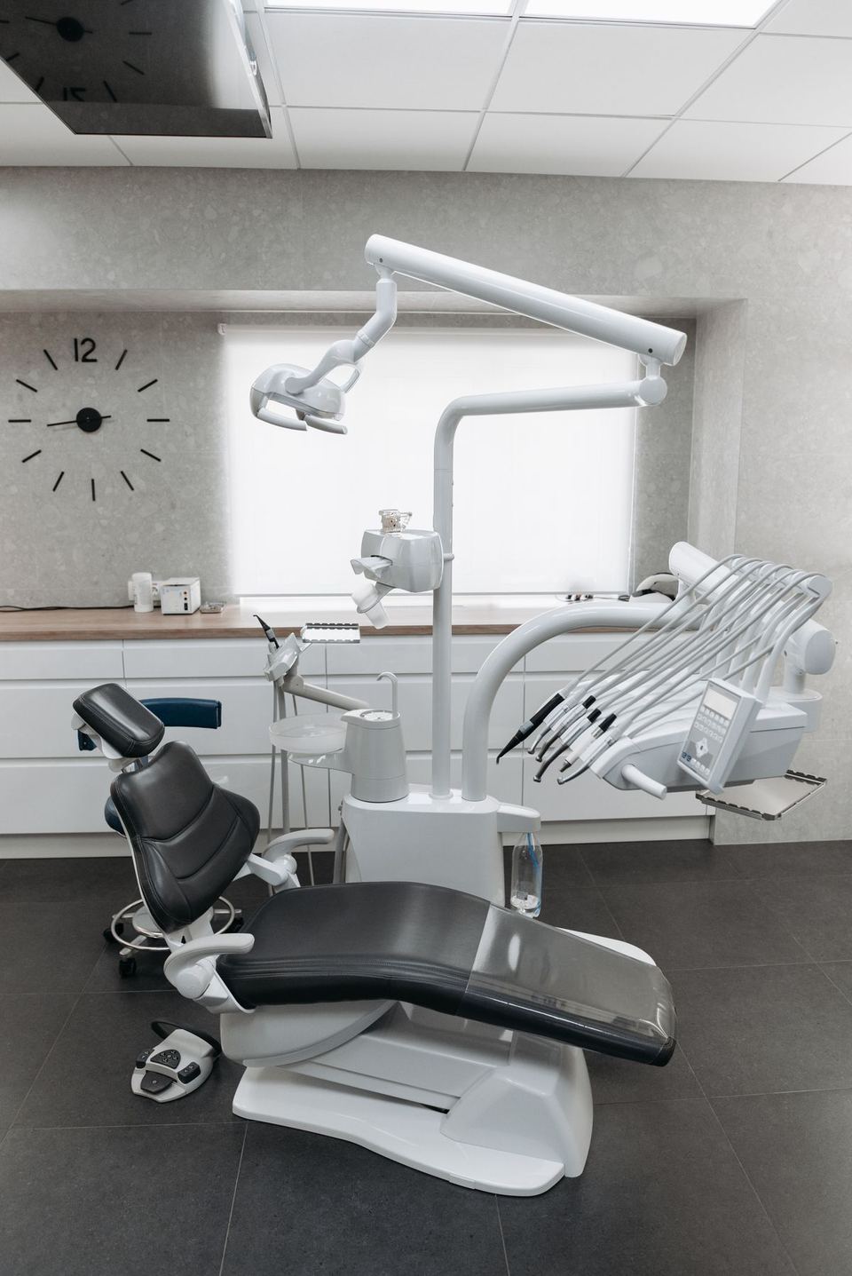 An empty dental room with a dental chair and equipment